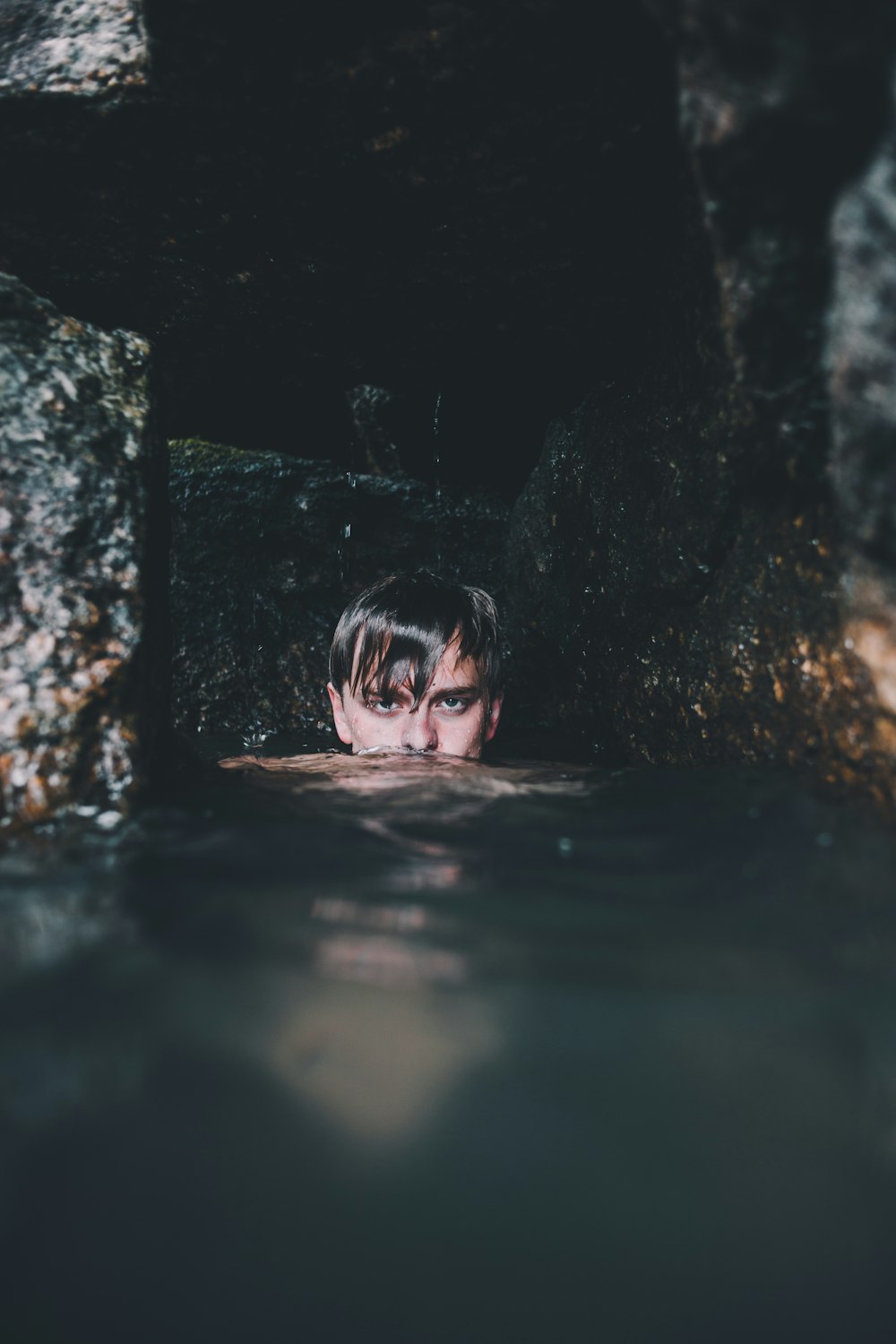 man near rock formation soaking on water