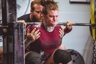 A trainer guiding a client through a powerlifting session.