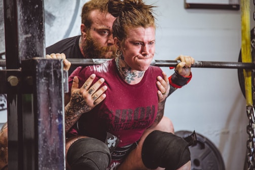 A trainer guiding a client through a powerlifting session.