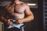 a hairy lighter skinned, shirtless man wearing a weight lifting belt