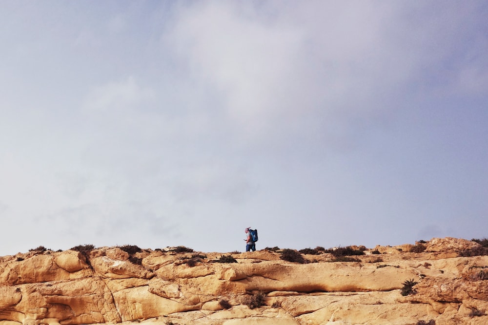 a man standing on top of a rocky cliff