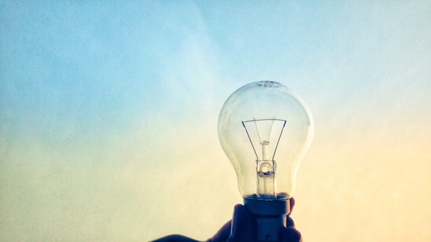 Close-up of hands exchanging a lightbulb symbolizing innovative ideas and intellectual property.