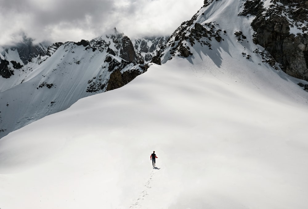 man climbing snow-covered mountain