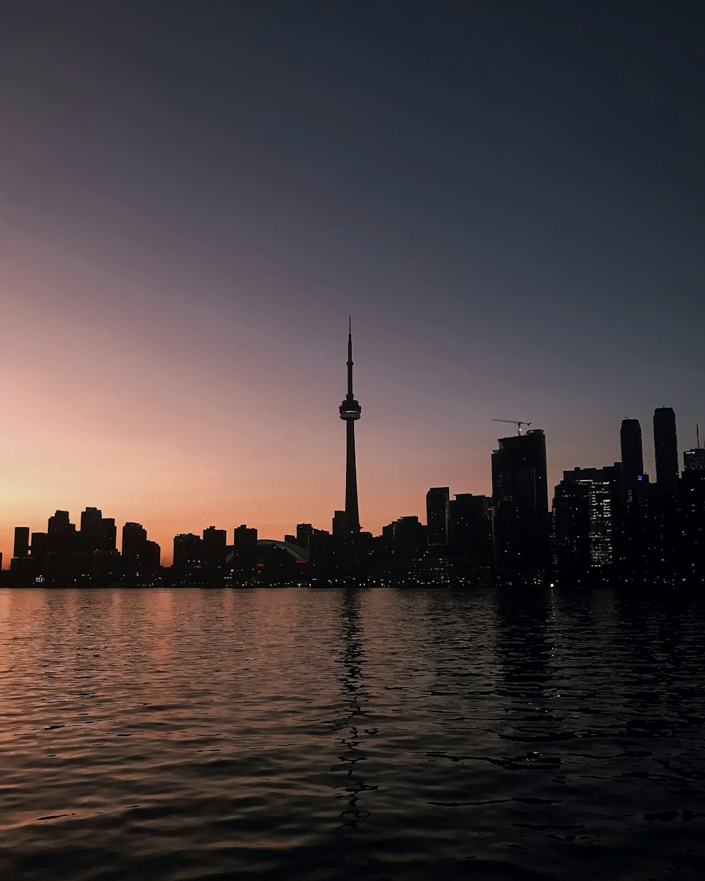 body of water surrounded by buildings under gray sky during sunset