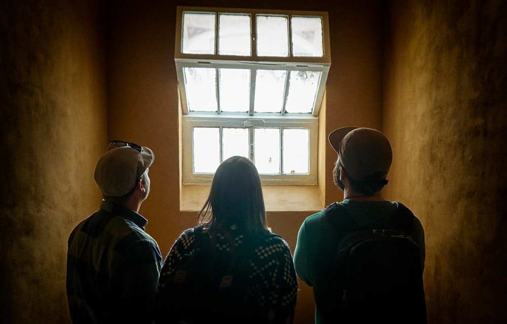 three people facing window