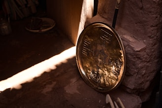 Close-up of a shiny, intricately engraved Moroccan copper tray with warm lighting.