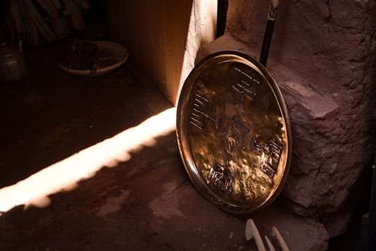 Close-up of a shiny, intricately engraved Moroccan copper tray with warm lighting.