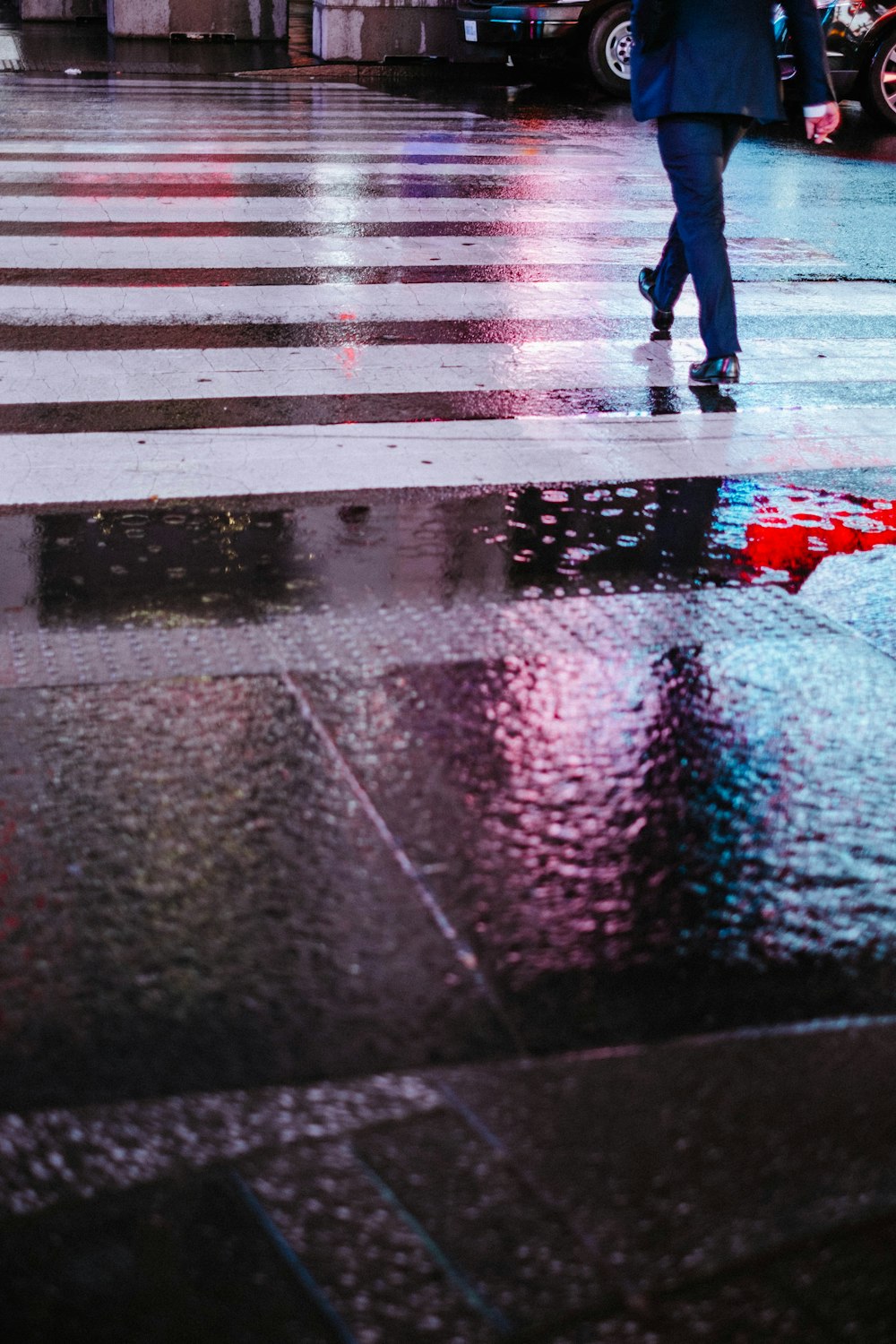 person wearing suit jacket walking on pedestrian lane