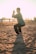man closing his hands white squatting on sand