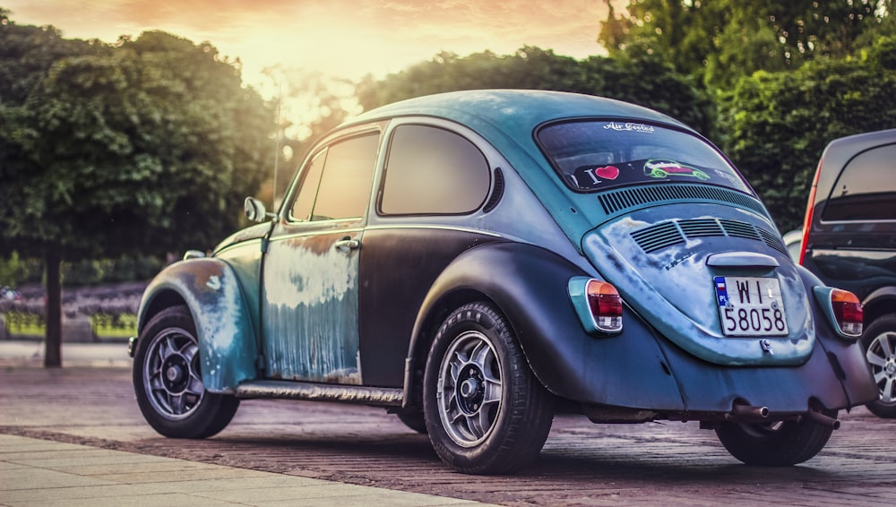 blue Volkswagen Beetle on gray road