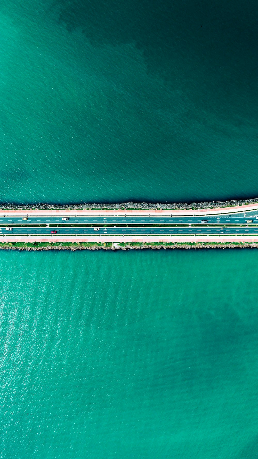 aerial photography of road between body of water