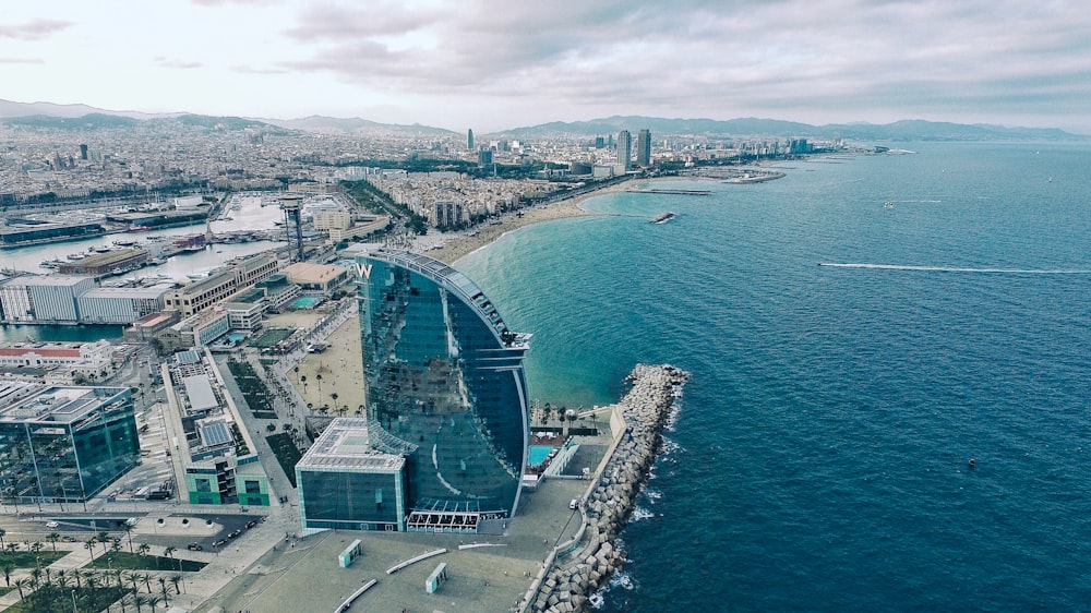 Edifício de vidro transparente perto do mar sob o céu cinzento