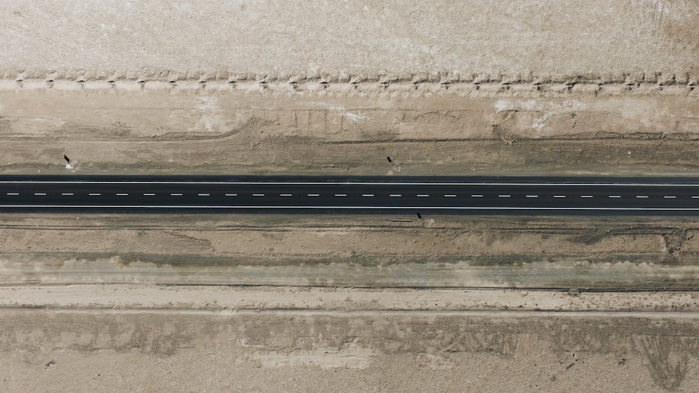 an overhead view of a road with a car driving on it