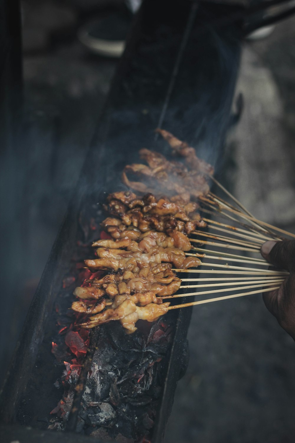 Persona sosteniendo brochetas de carne