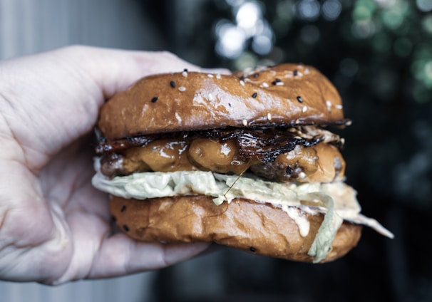 person holding burger with meat