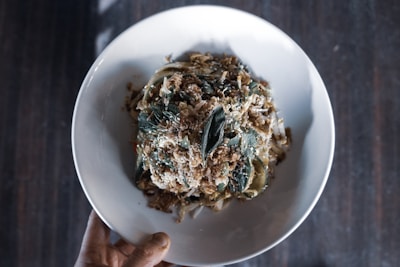 Hands holding a warm, homemade gluten-free meal plated beautifully.