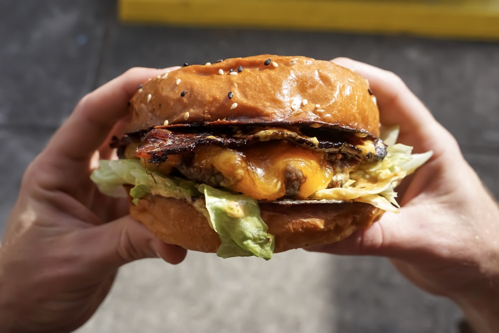 チーズバーガーを手にする人