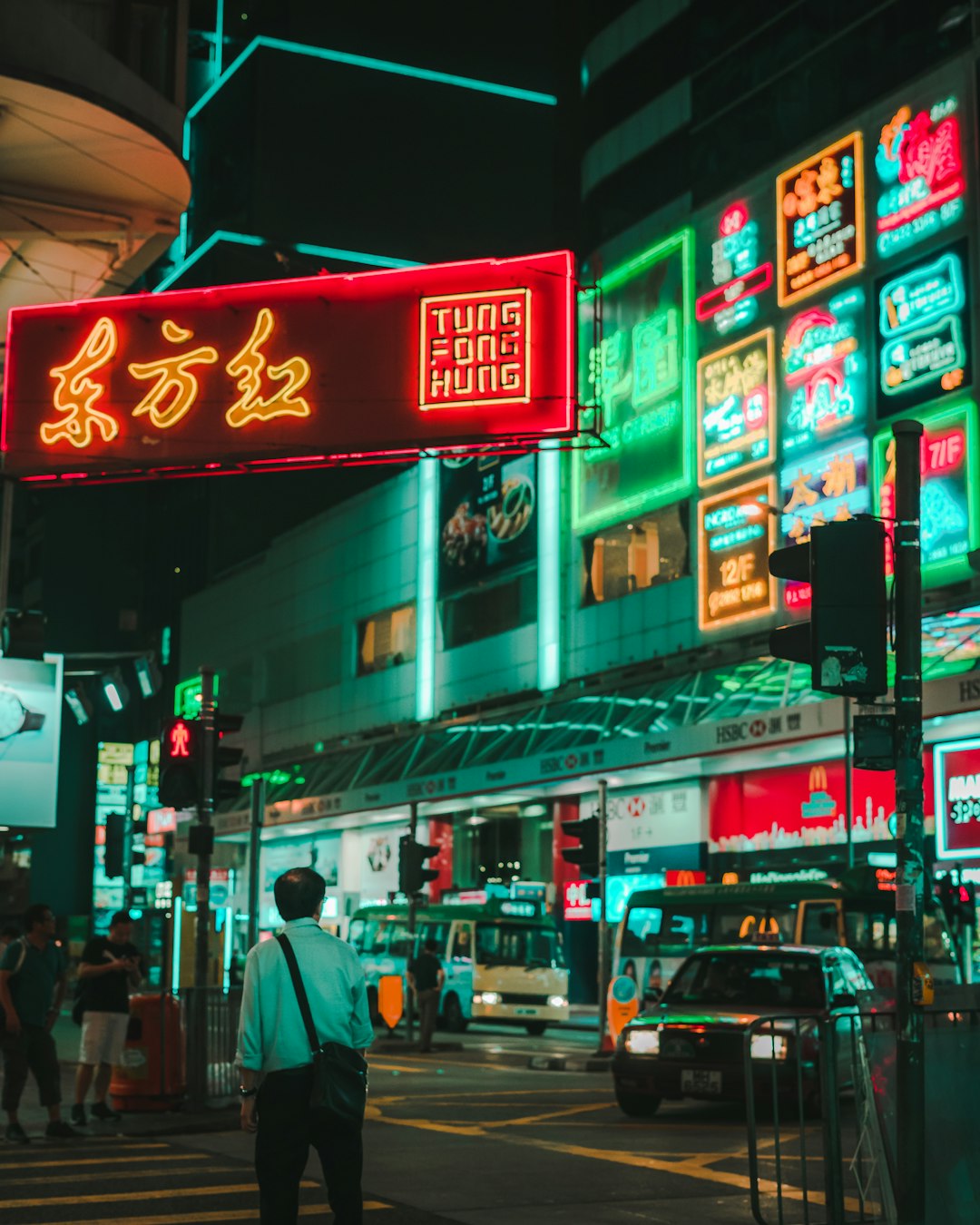 man walking on street under tung fong hung signage