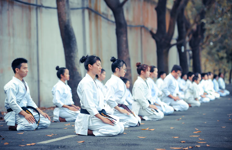 A karate student bowing on the dojo mat before training
