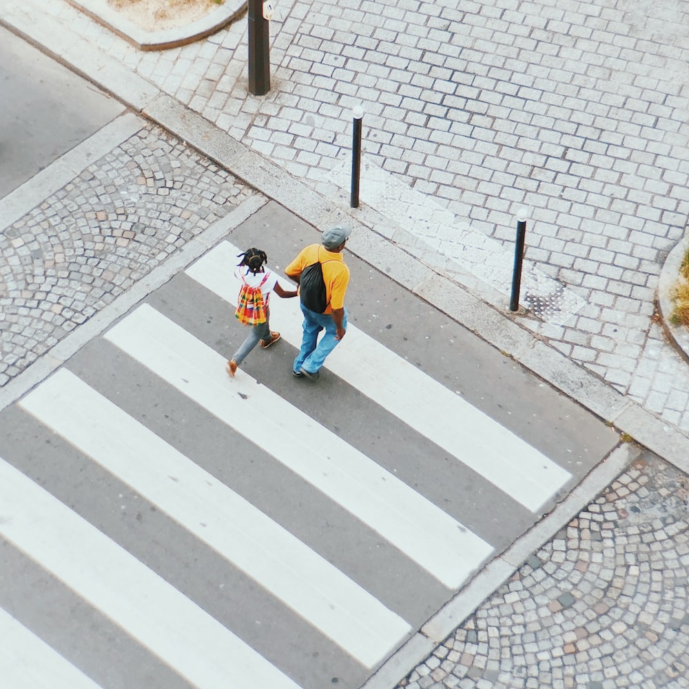 Hombre y niña cruzando en carril peatonal