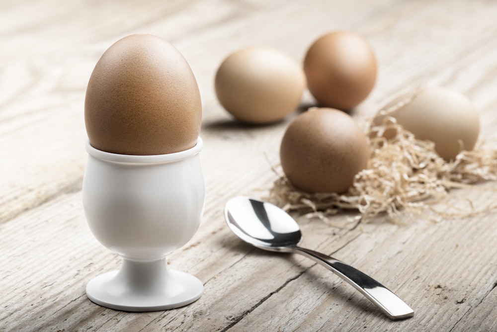 white ceramic egg holding near spoon