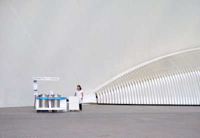 woman wearing white dress and black pants near stall fresh zoom background