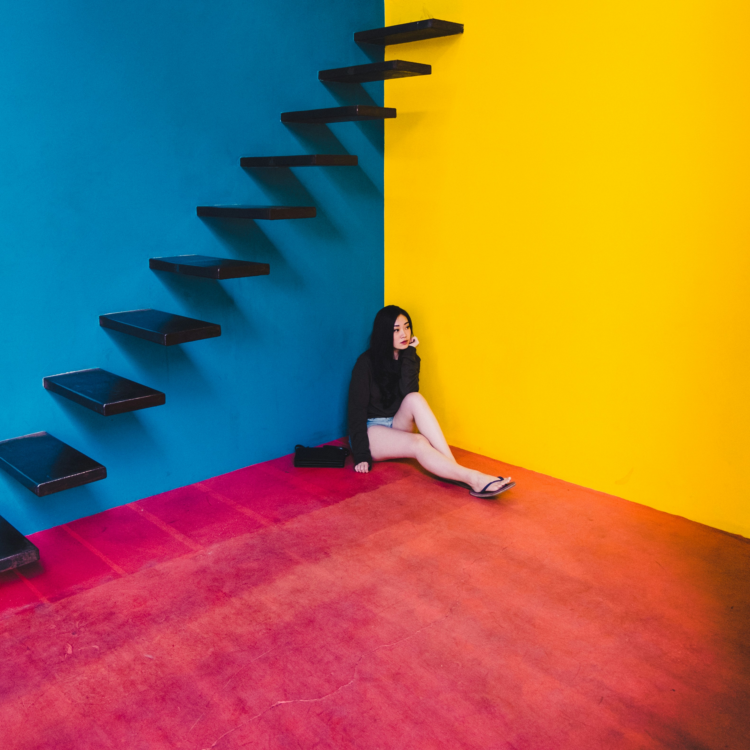 great photo recipe,how to photograph colorful; woman wearing black long-sleeved shirt sitting on the corner of building