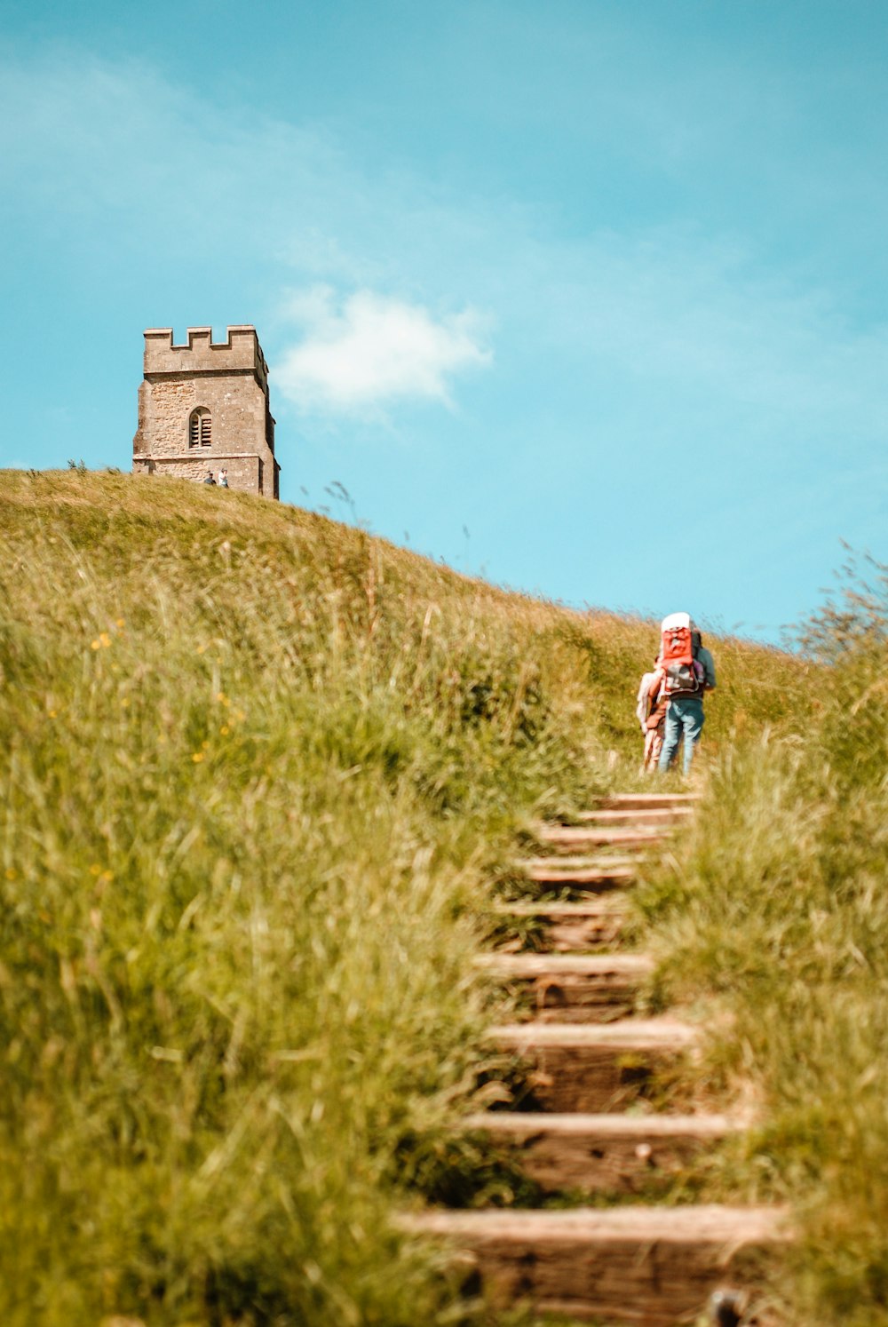 two person walks on hills near concrete stucture