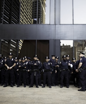 group of police standing near grey building