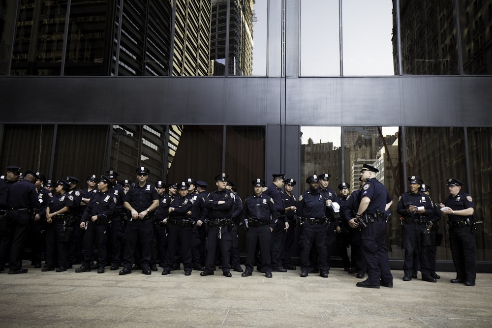 Grupo de policiais perto do prédio cinza