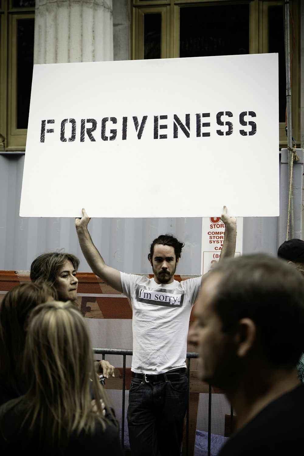 persona que sostiene el cartel del perdón