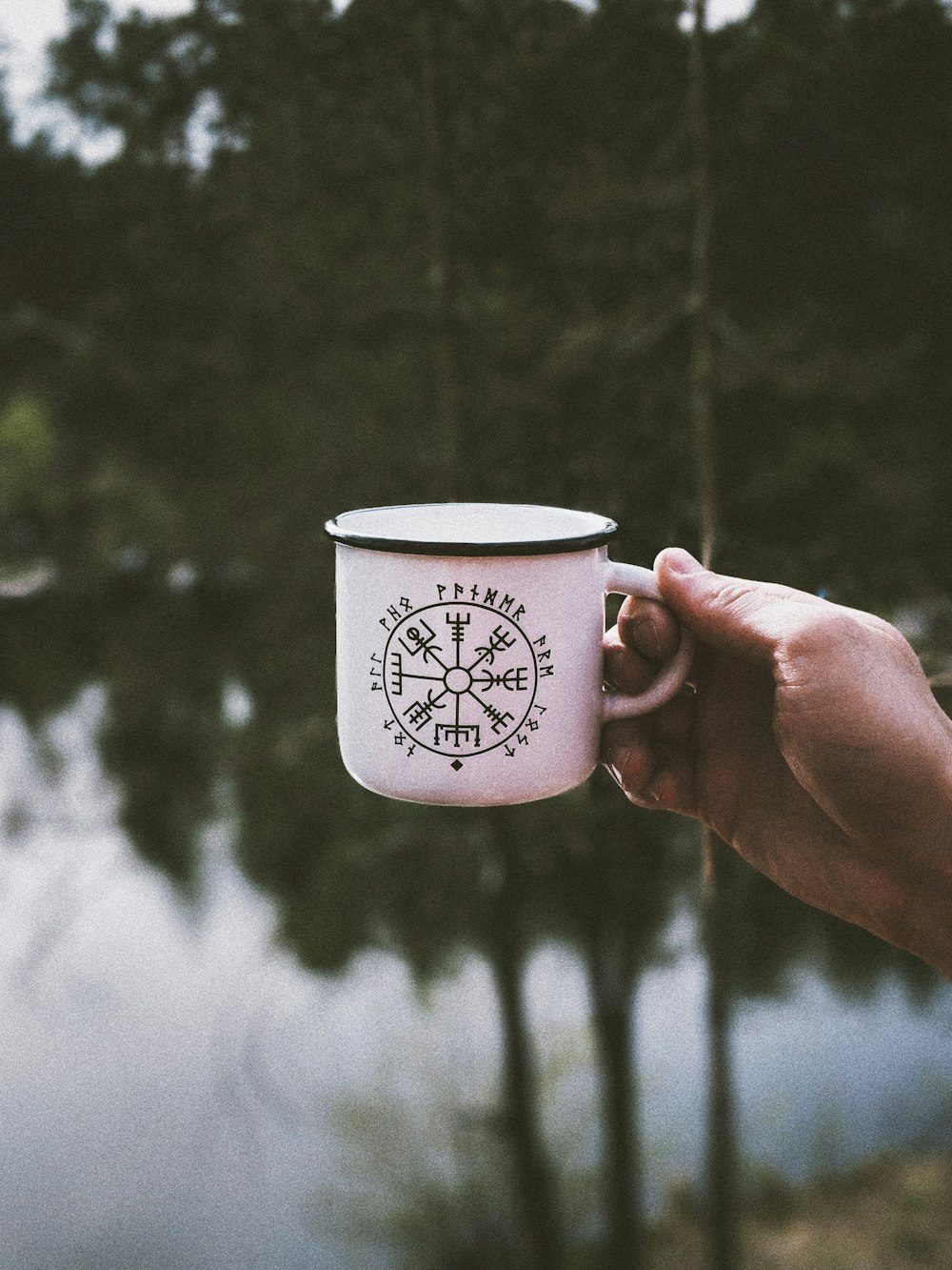 person holding white cup outdoor during daytime