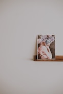 A vibrant photo frame displayed on a rustic wooden shelf surrounded by soft fairy lights.