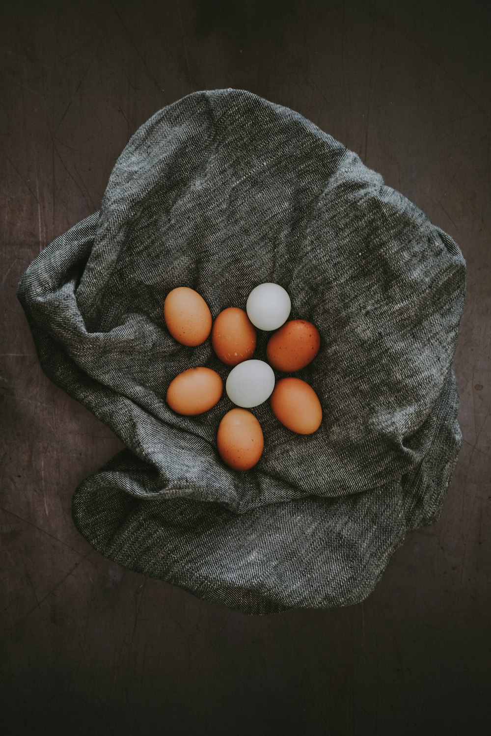 Lote de ovos brancos e marrons em tecido cinzento
