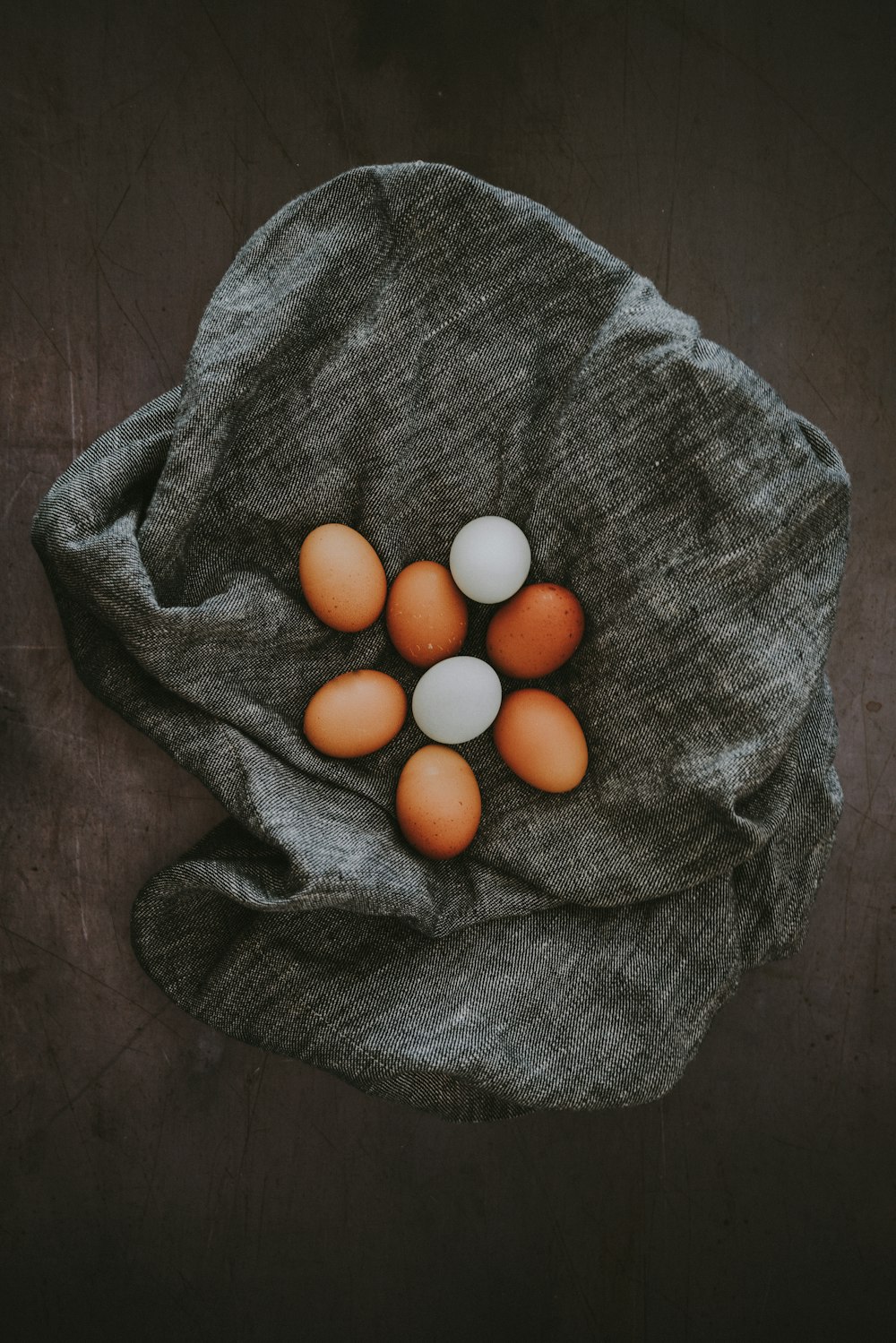 white and brown egg lot on grey textile