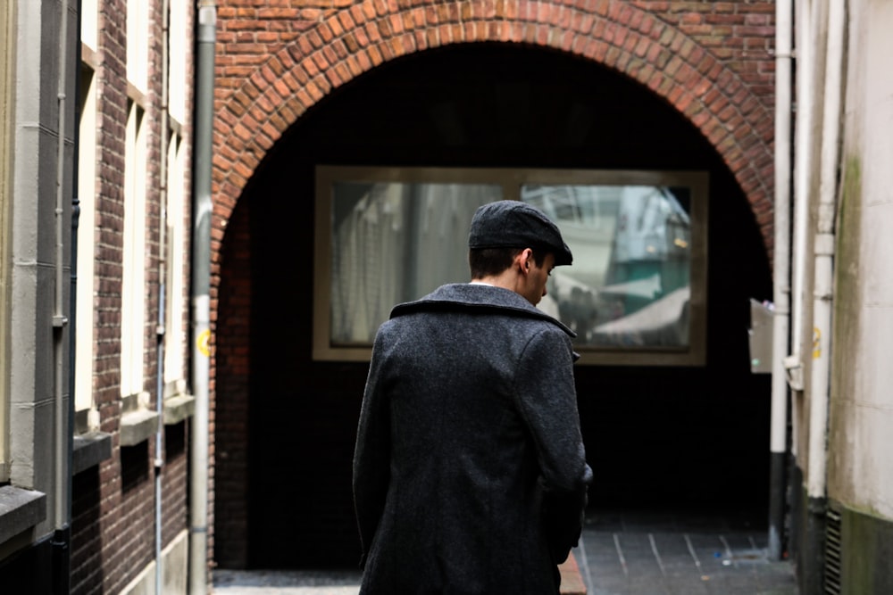 person walking on street near white building