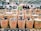Photo of a woman inspecting spices in a warehouse with crates of dried fruits nearby.