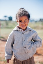 girl wearing grey button-up jacket while smiling
