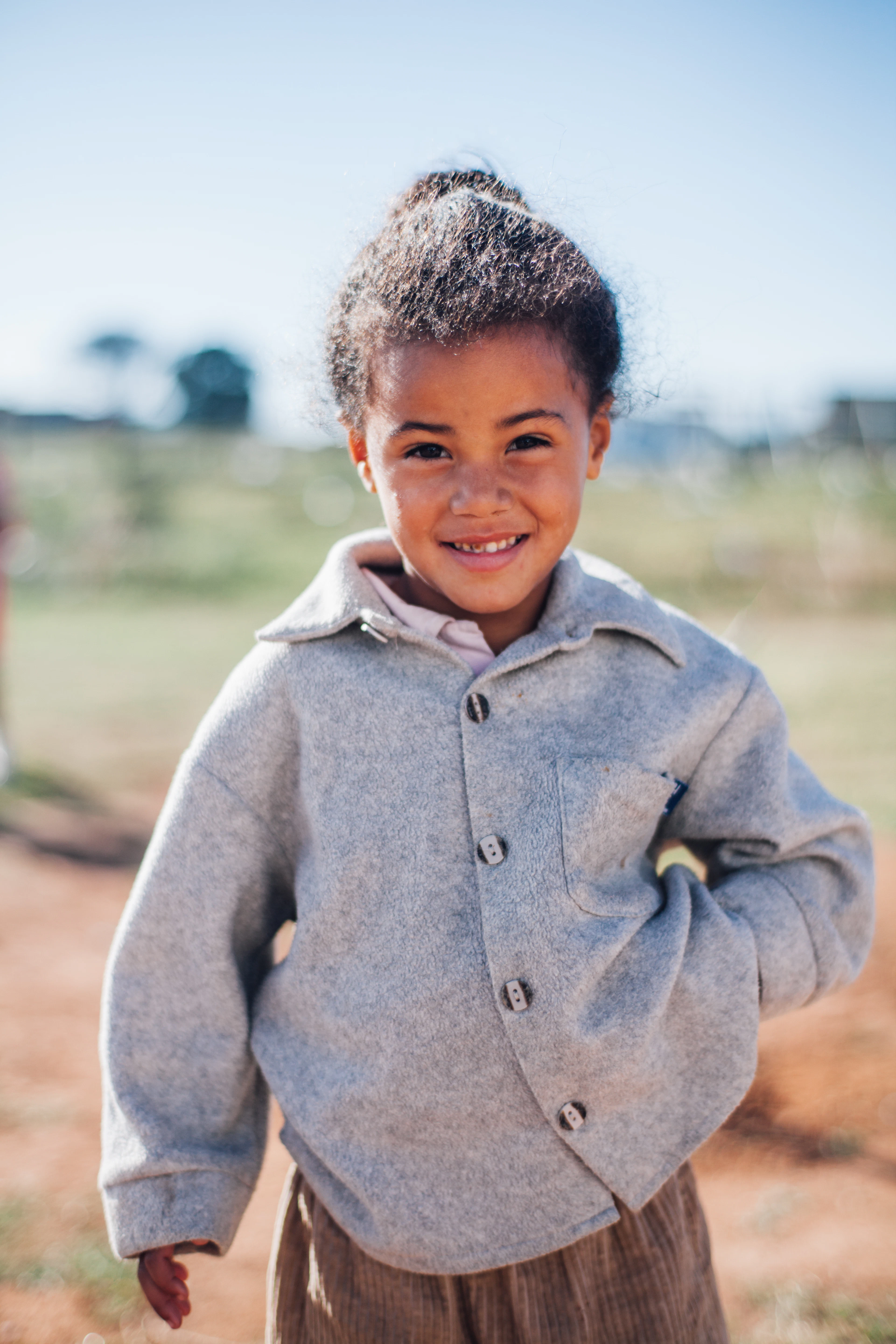 A smiling girl in a gray fleece jacket