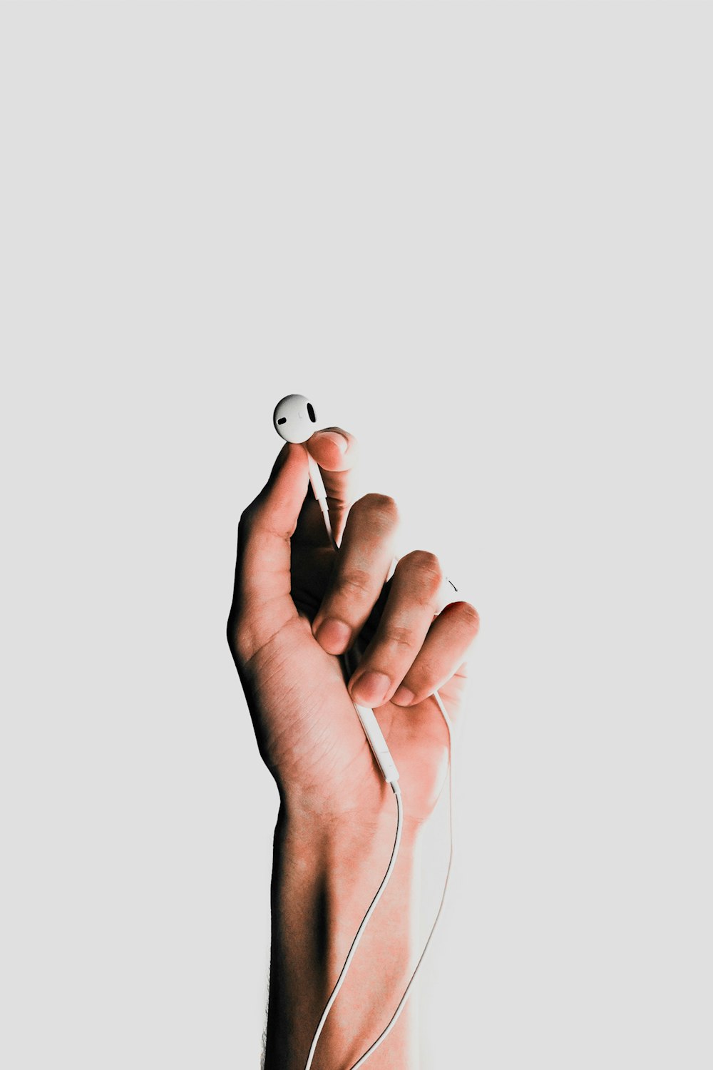 person holding Apple EarPods