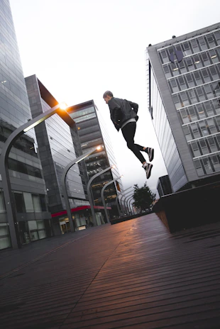 Dynamic parkour runner leaping between rooftops in a vibrant urban setting.