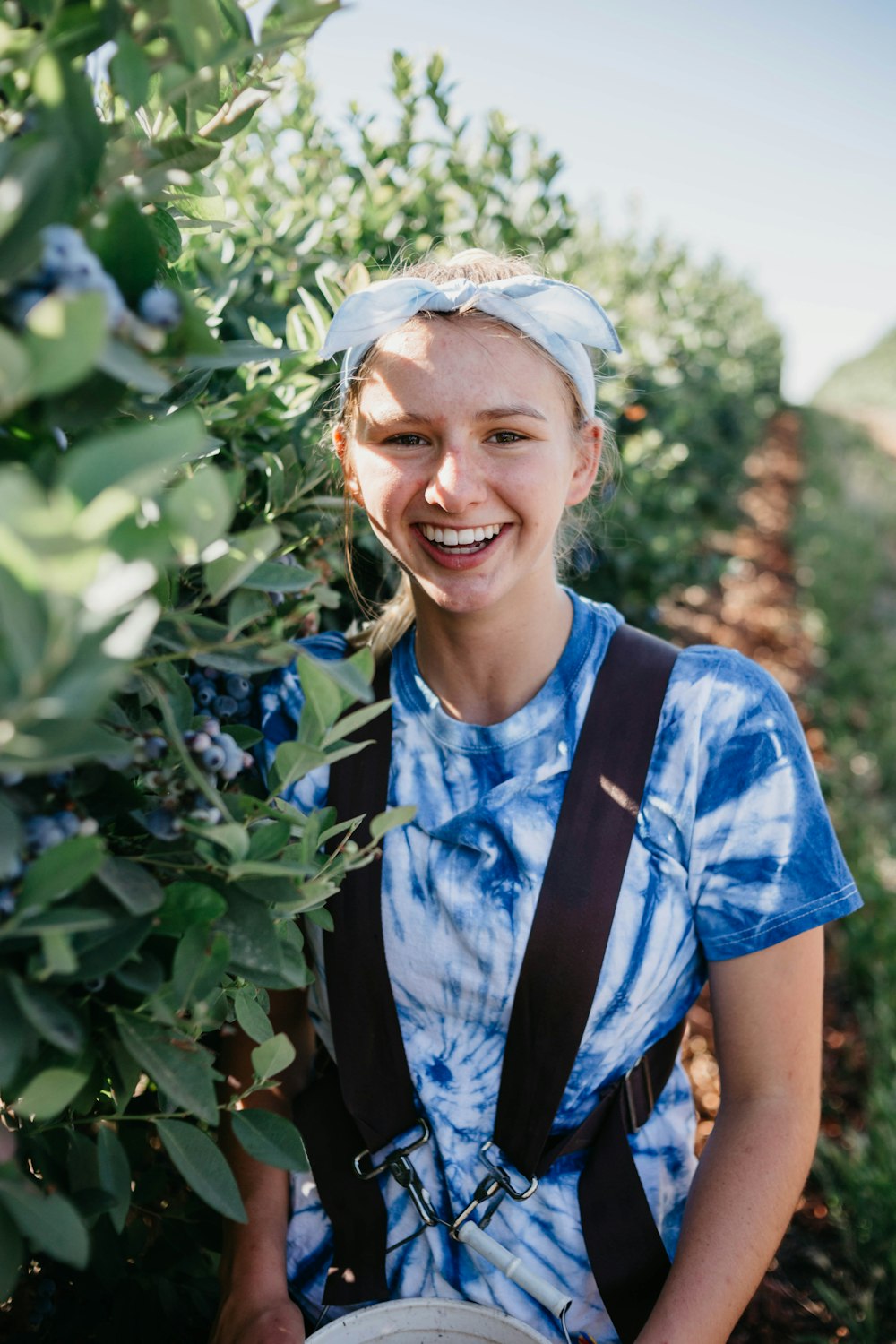 selective focus photography of woman standing beside green leafed plant