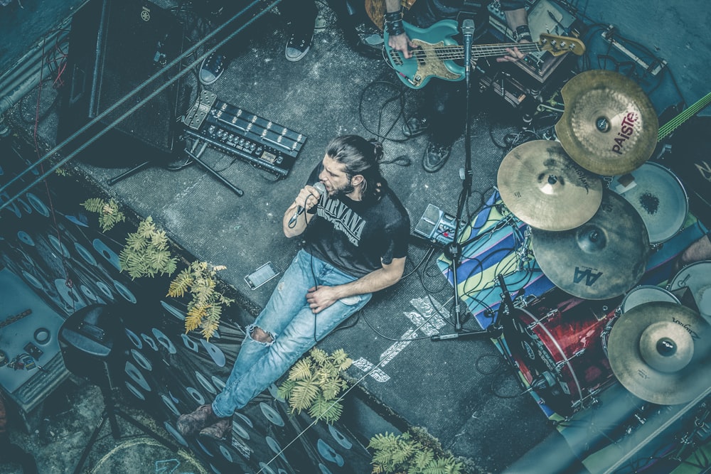 man sitting while singing beside instruments