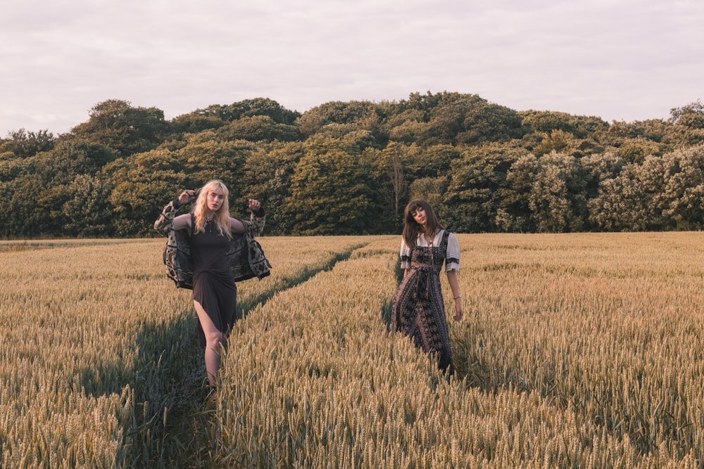 two women standing on paddy field while taking photo