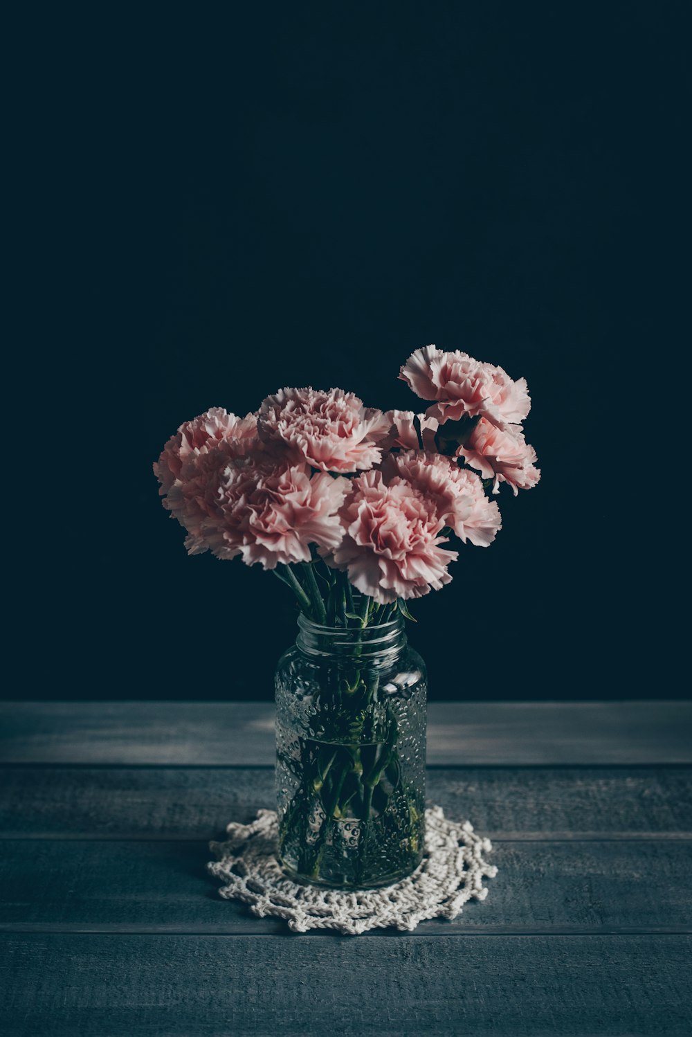 회색 나무 테이블에 분홍색 꽃잎 꽃 중앙 장식