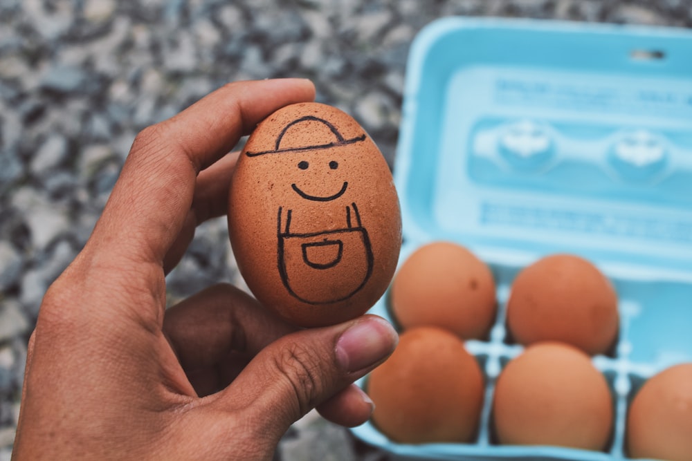 person holding brown egg