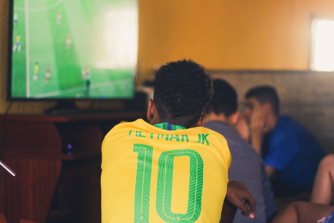 Football fan in Brazil shirt watching streamed match