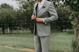 standing man holding his notched lapel suit jacket's button