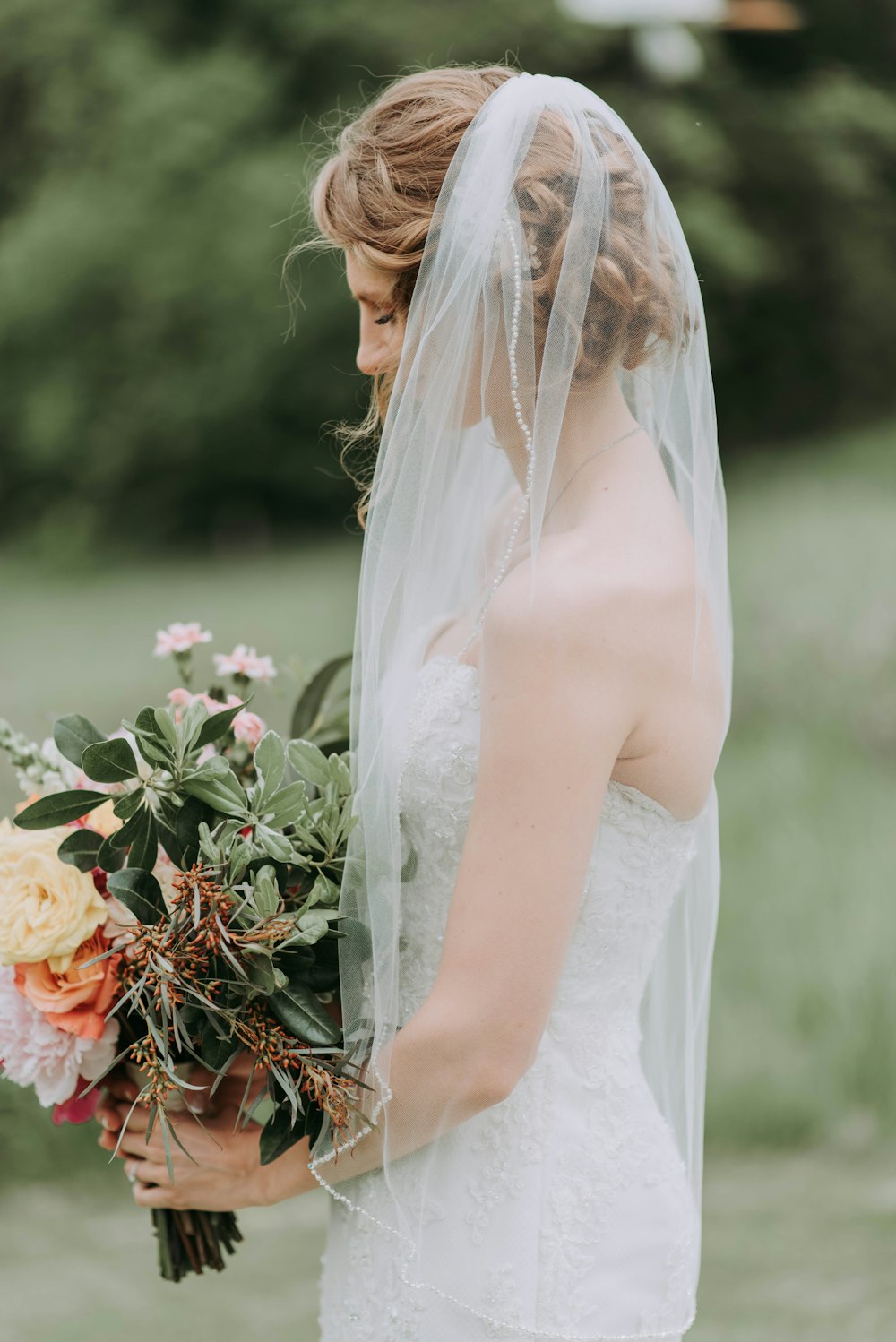 femme portant une robe de mariée blanche avec un voile