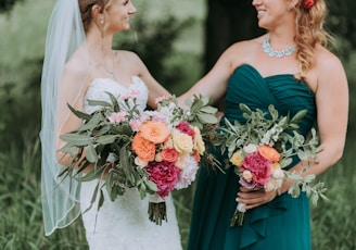 bride holding bouquet of assorted-color flowers standing on grass field